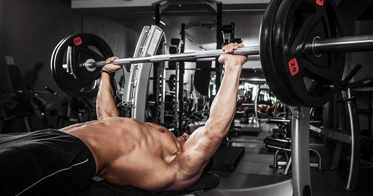 Mann drückt beim Bankdrücken 100 kg